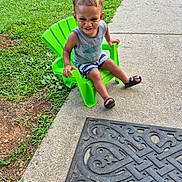 La'Kailyn is registered to the contest to win money with this photo: child, toddler, green_chair, smiling, outdoor, grass, concrete, sidewalk, doormat, footwear, sandals, shorts, tank_top, happy, person, summer, playful, young_child, nature, casual