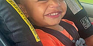 La'Kailyn joined the competition — help win amazing prizes! child, toddler, car_seat, smiling, orange_shirt, seatbelt, happy, face, hair, window, car_interior, safety, seat, travel, cute, expression, daylight, vehicle, young_child, portrait