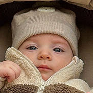 Edward participe au concours pour gagner de l'argent avec cette photo : baby, infant, child, face, hat, knit_hat, jacket, zipper, fleece, brown, cream, blue_eyes, hand, cushion, soft_fabric, warm_clothing, close_up, portrait, indoor, cute