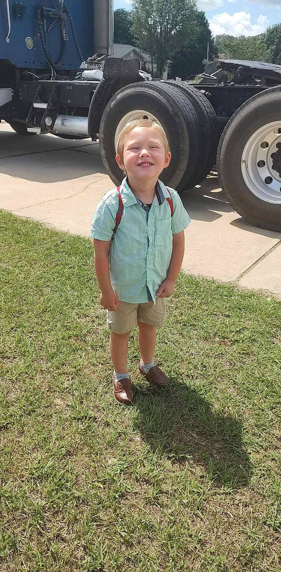 Matthew is registered to the contest to win money with this photo: asphalt, auto_part, automotive_exterior, automotive_lighting, automotive_tire, automotive_wheel_system, bumper, gas, grass, joy, light, motor_vehicle, person, rim, shorts, smile, synthetic_rubber, tire, toddler, tread