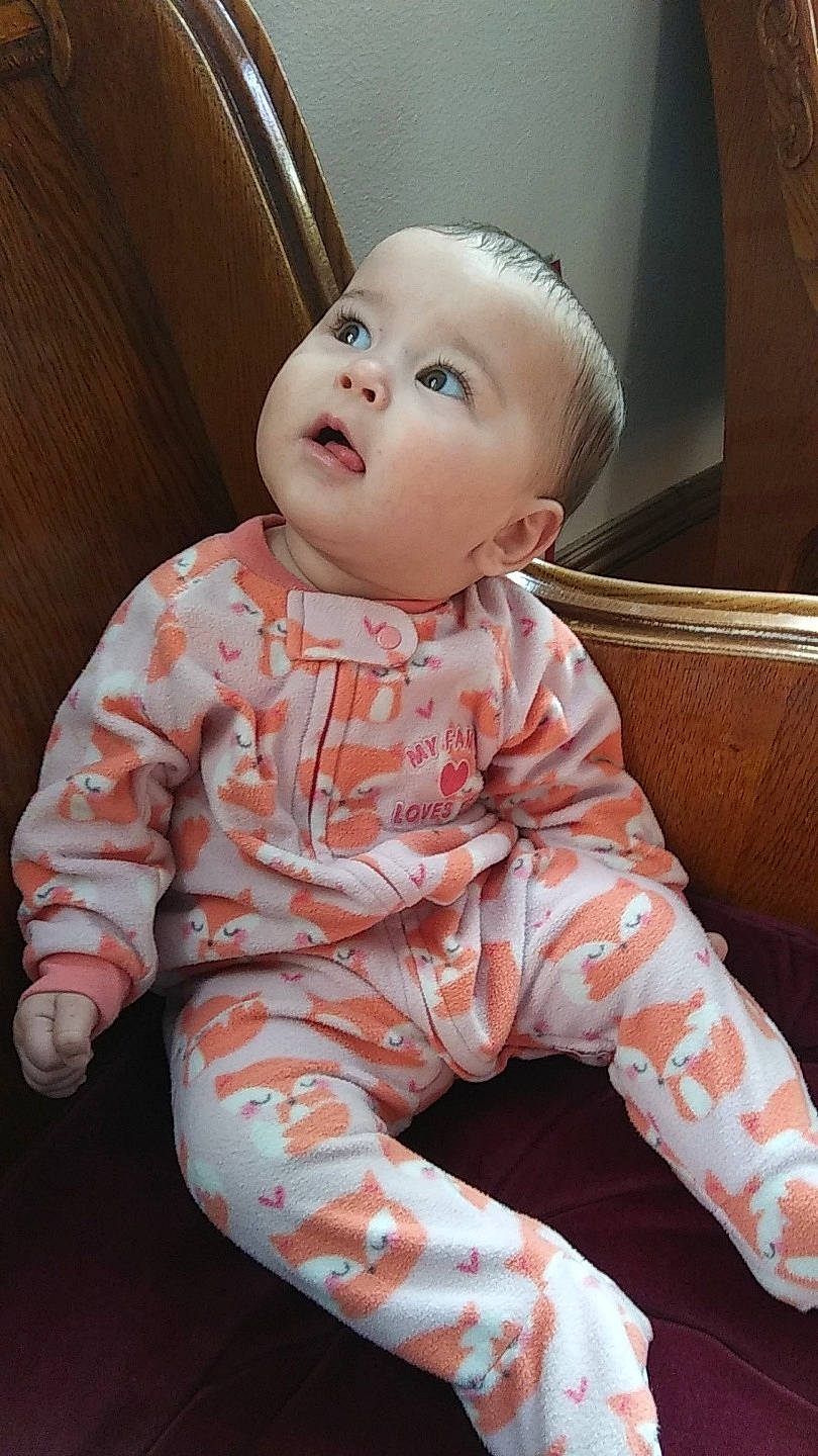 Emberlynn is registered to the contest to win money with this photo: baby, cheek, child, face, head, lip, person, sitting, skin, sleeve, surprise, toddler