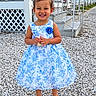 child, girl, toddler, smiling, portrait, outdoor, dress, floral_dress, blue_bow, standing, gravel, porch, house, summer, fashion, happy, shoes, garden, daylight, person