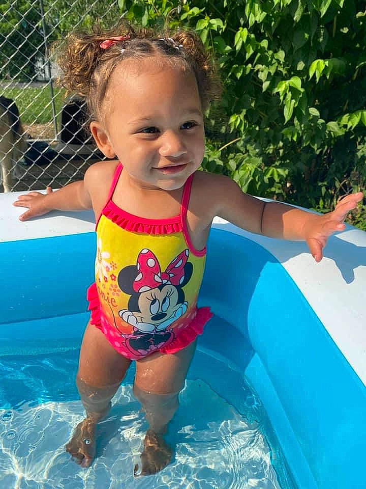 Alaiyah is registered to the contest to win money with this photo: baby_toddler_clothing, bathing, child, face, fun, grass, happy, inflatable, joy, leisure, person, personal_protective_equipment, photograph, plant, recreation, smile, summer, swimming_pool, swimwear, thigh
