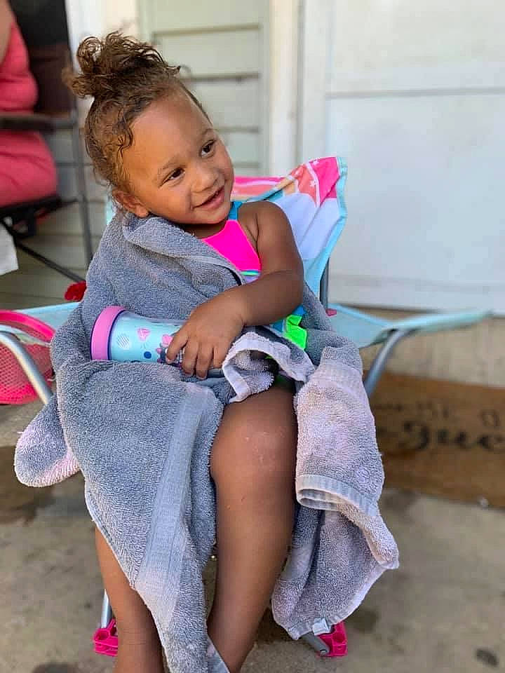 Alaiyah joined the competition — help win amazing prizes! baby_toddler_clothing, chair, comfort, facial_expression, fun, happy, human_leg, joint, knee, lap, leg, leisure, magenta, person, pink, sandal, skin, smile, thigh, toddler