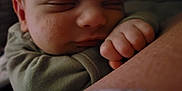 Rónán is registered to the contest to win money with this photo: baby, sleeping, close_up, face, hand, fist, skin, arm, clothing, peaceful, resting, soft_lighting, infant, portrait, tender_moment, cute, young_child, indoors, human, child