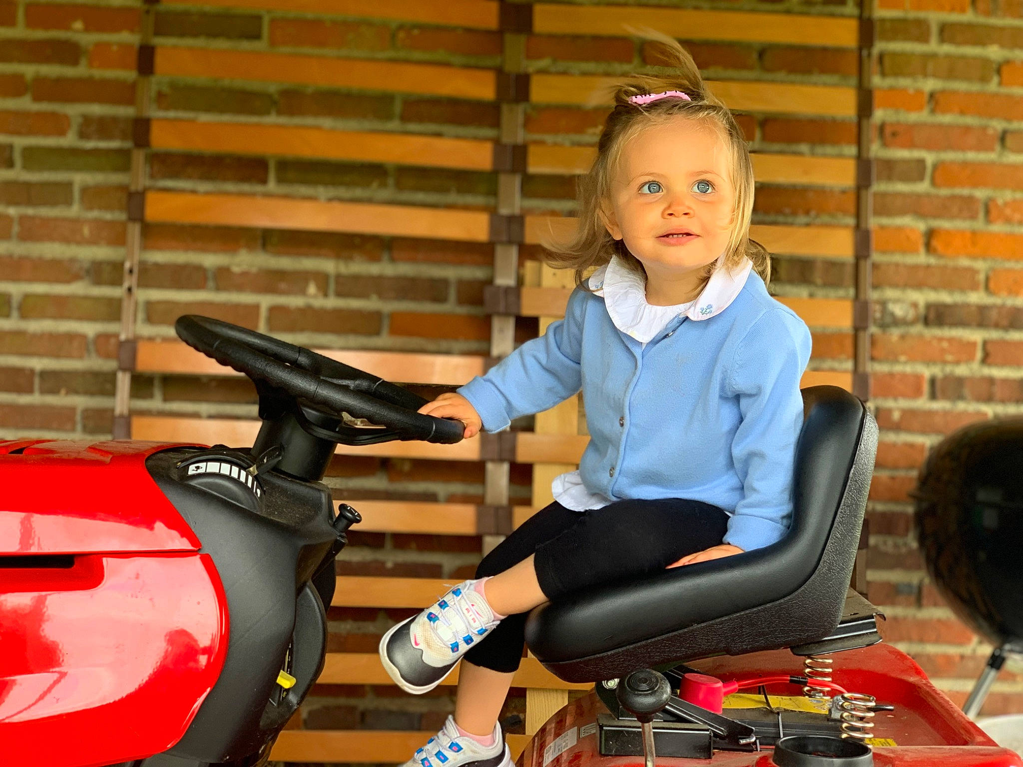 Sara participe au concours pour gagner de l'argent avec cette photo : automotive_design, automotive_lighting, automotive_tire, automotive_wheel_system, baby_toddler_clothing, brick, brickwork, fun, happy, human_leg, knee, leisure, motor_vehicle, person, recreation, sitting, thigh, tire, toddler, vehicle