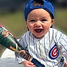 Maverick joined the competition — help win amazing prizes! baby, child, smiling, laughing, baseball, baseball_bat, baseball_jersey, baseball_cap, chicago_cubs, sports, outdoor, portrait, infant, happy, face, blue_cap, white_uniform, bat, seated, close_up