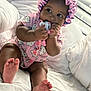 baby, bed, bonnet, child, chubby_cheeks, cute, face, feet, hand, hello_kitty, indoors, infant, looking_away, pacifier, pink_clothing, portrait, sitting, sleepwear, soft_light, white_bedspread