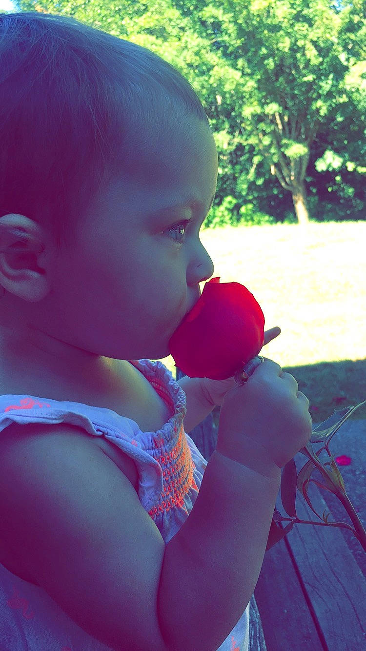 Kennedy is registered to the contest to win money with this photo: baby, baby_toddler_clothing, child, finger, gesture, grass, happy, iris, leaf, lip, nose, person, pink, plant, skin, smile, summer, sunlight, tints_and_shades, toddler