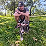Gunner is registered to the contest to win money with this photo: animal, casual_clothing, crouching, daylight, dog, grass, happy, hat, leaf, man, nature, outdoor, park, pet, playful, puppy, sneakers, sunlight, tree, young_adult