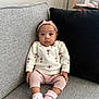 Ylona Margaret is registered to the contest to win money with this photo: baby, infant, child, sitting, couch, sofa, sweater, pink_headband, pink_socks, knitted_pants, flower_pattern, indoor, person, cute, portrait, cozy, comfortable, looking_at_camera, headband, small_child