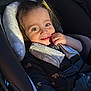 toddler, child, car_seat, smile, happy, straps, sunlight, face, clothing, seatbelt, baby, infant, young_child, cute, portrait, indoors, cozy, warm_light, person, babywear