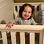 toddler, child, crib, smiling, happy, indoors, baby, person, furniture, wood, hand, face, clothing, bedroom, portrait, cute, young, standing, expression, home