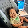 baby, child, smiling, car_seat, curly_hair, dimple, tshirt, indoor, car_interior, happy, cute, infant, seatbelt, black_leather, automobile, seat, gas_station, door, joyful, portrait