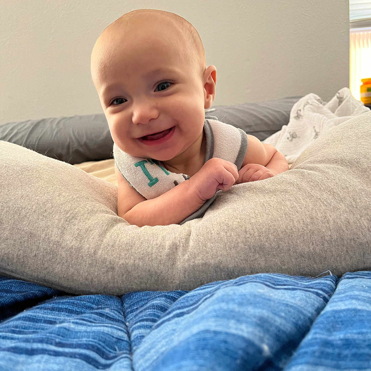 Elliott is registered to the contest to win money with this photo: baby, babylaughing, bed, bedroom, blanket, clothing, cushion, face, furniture, happy, head, homedecor, indoors, pants, person, photography, portrait, quilt, room, smile
