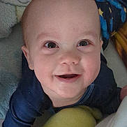 Lisandro a rejoint le concours — aidez-le/la à gagner de superbes lots ! baby, infant, smile, face, eyes, cheeks, close_up, portrait, happy, gummy_smile, blanket, pajamas, blue_clothing, yellow_plush, soft_toys, nursery, head, skin, bed, cozy