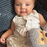 Seya participe au concours pour gagner de l'argent avec cette photo : baby, child, blue_eyes, curly_hair, white_outfit, stuffed_animal, couch, pillow, comfort, cute, smile, indoor, plush_toy, relaxed, infant, portrait, soft_lighting, happy, closeup, casual