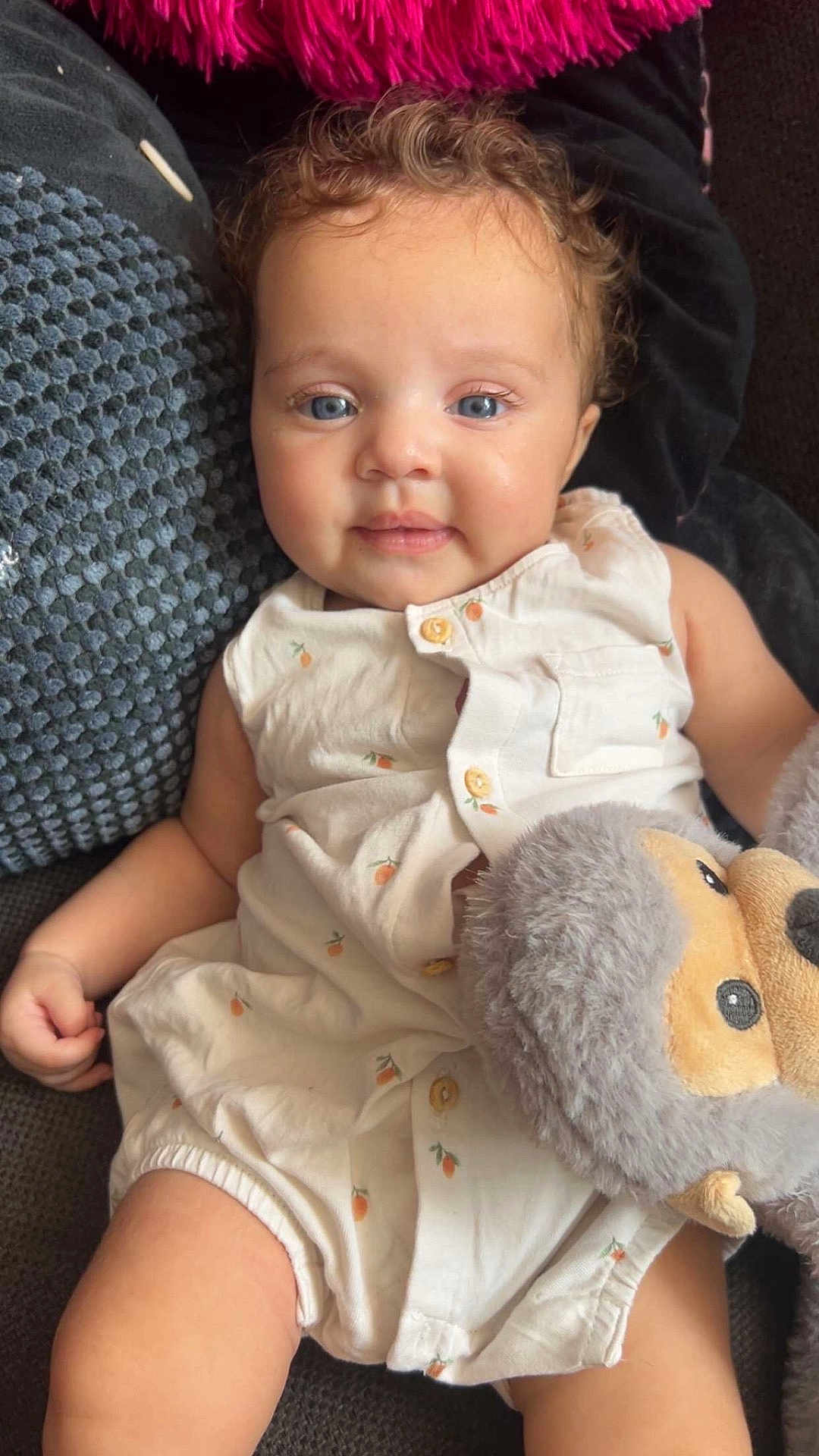 Seya participe au concours pour gagner de l'argent avec cette photo : baby, child, blue_eyes, curly_hair, white_outfit, stuffed_animal, couch, pillow, comfort, cute, smile, indoor, plush_toy, relaxed, infant, portrait, soft_lighting, happy, closeup, casual