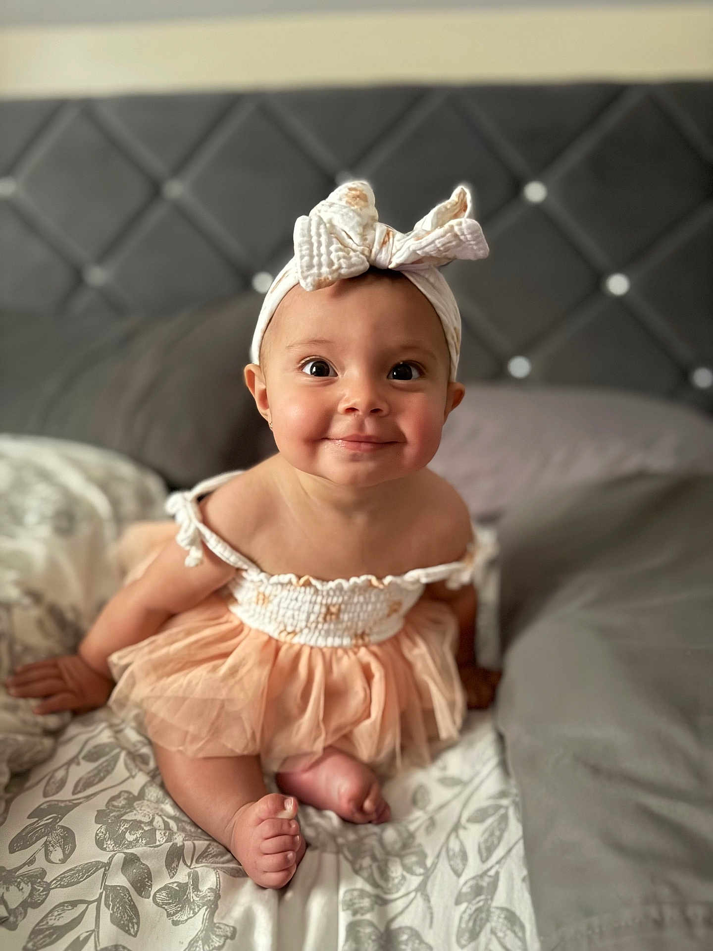 Olive is registered to the contest to win money with this photo: baby, child, girl, headband, bow, dress, bed, blanket, smile, happy, cute, infant, indoor, portrait, skin, foot, hand, eyes, clothing, toddler