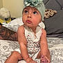 baby, bed, blanket, child, cute, expression, flower, foot, hand, headband, indoors, infant, looking_up, person, pillow, romper, sitting, skin, tattoo, young