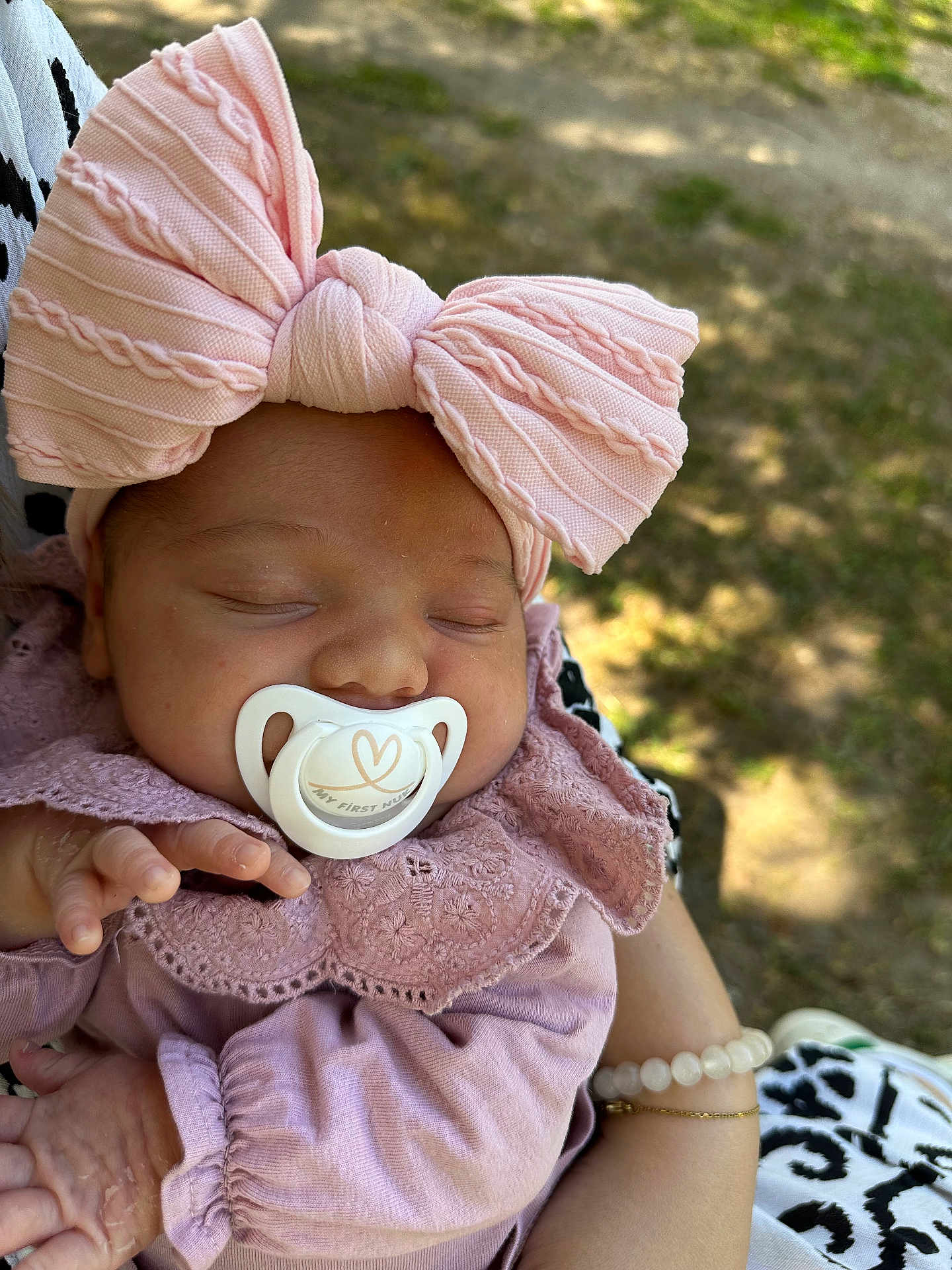 Ambre participe au concours pour gagner de l'argent avec cette photo : baby, sleeping, pacifier, headband, bow, pink_clothing, lace, hand, arm, outdoor, sunlight, person, infant, closeup, peaceful, cute, soft_light, nature, portrait, resting