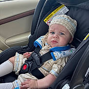 Matthew joined the competition — help win amazing prizes! baby, child, car_seat, car_interior, seat_belt, clothing, headwear, expression, face, person, sitting, safety, vehicle, window, road, trees, daylight, cute, infant, transport