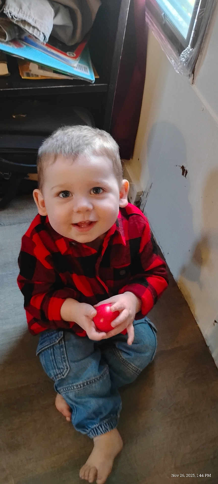 Calvin joined the competition — help win amazing prizes! toddler, child, smiling, red_ball, barefoot, jeans, checkered_shirt, indoor, floor, window, shelf, toy, happy, young_child, person, casual_clothing, light, face, hands, sitting
