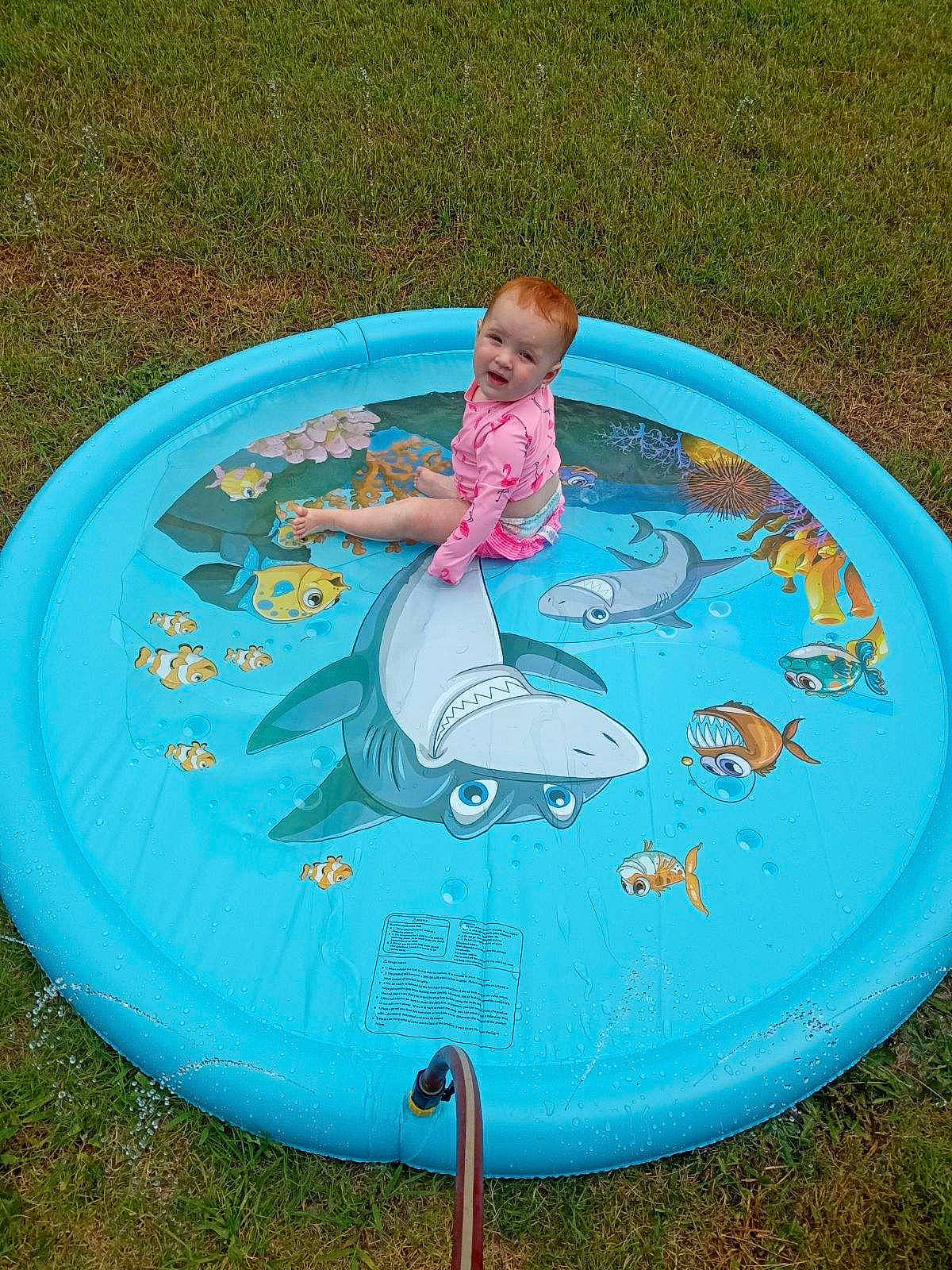 Alayna is registered to the contest to win money with this photo: aqua, baby, baby_products, baby_toddler_clothing, child, circle, electric_blue, fun, games, grass, inflatable, leisure, nonbuilding_structure, outdoor_recreation, person, play, product, recreation, surfboard, toddler