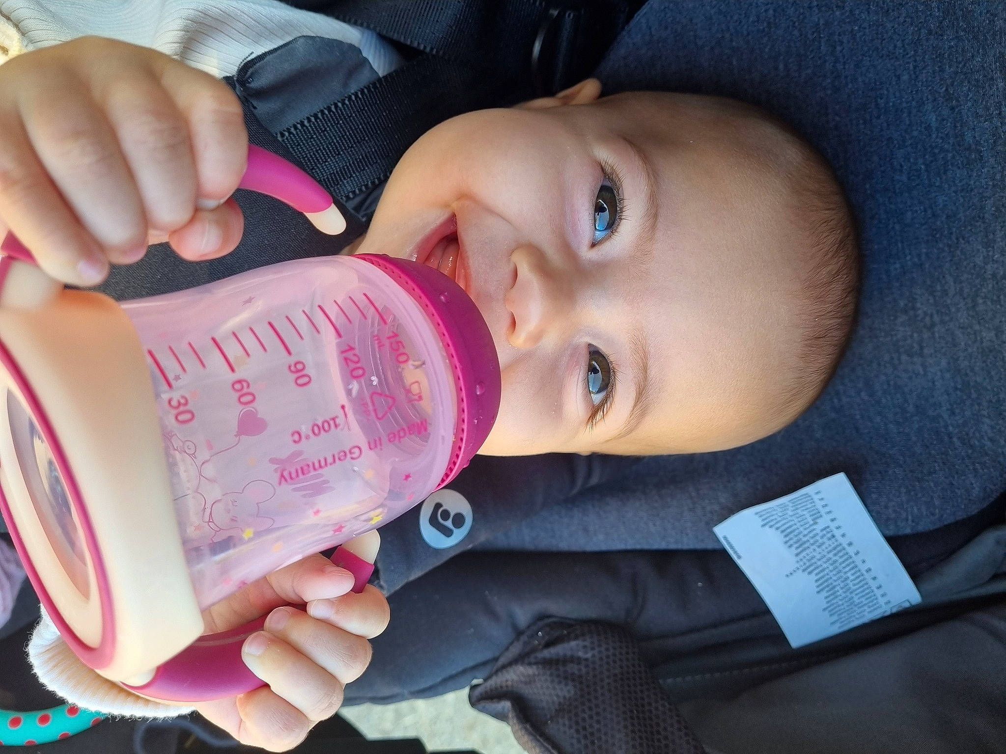 Nelly a rejoint le concours — aidez-le/la à gagner de superbes lots ! baby, bottle, cheek, drinkware, eye, eyebrow, fluid, gesture, hand, happy, head, human_body, iris, lip, mouth, nose, person, product, skin, smile