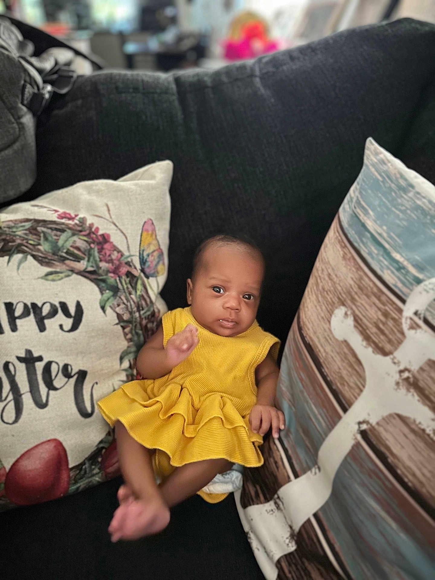 Zelestia is registered to the contest to win money with this photo: baby, yellow_dress, couch, pillow, happy_easter, infant, home_interior, decorative_pillow, smiling, child, cute, relaxing, indoors, soft_furniture, portrait, small_person, seated, face, comfort, cozy