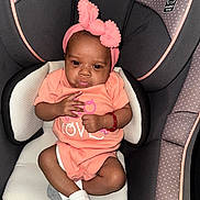 Zipporah joined the competition — help win amazing prizes! baby, infant, car_seat, graco, headband, bow, peach_outfit, socks, cute, child, seated, indoors, portrait, young_child, clothing, fabric, seat, comfort, expression, pout