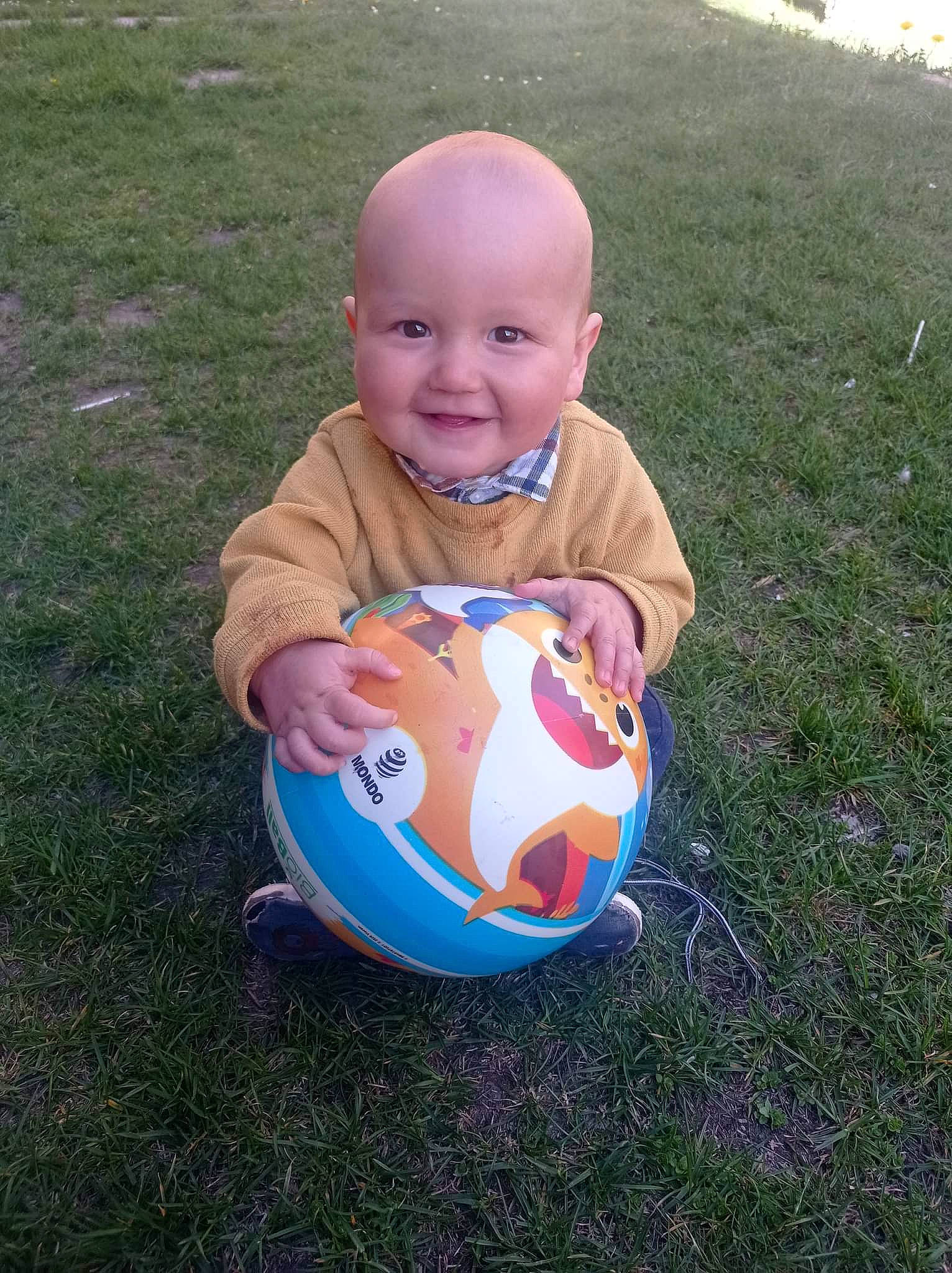 Logan participe au concours pour gagner de l'argent avec cette photo : arm, baby, baby_toddler_clothing, ball, face, football, grass, hand, happy, head, joy, people_in_nature, person, plant, recreation, smile, soccer_ball, sports_equipment, sports_gear, t_shirt