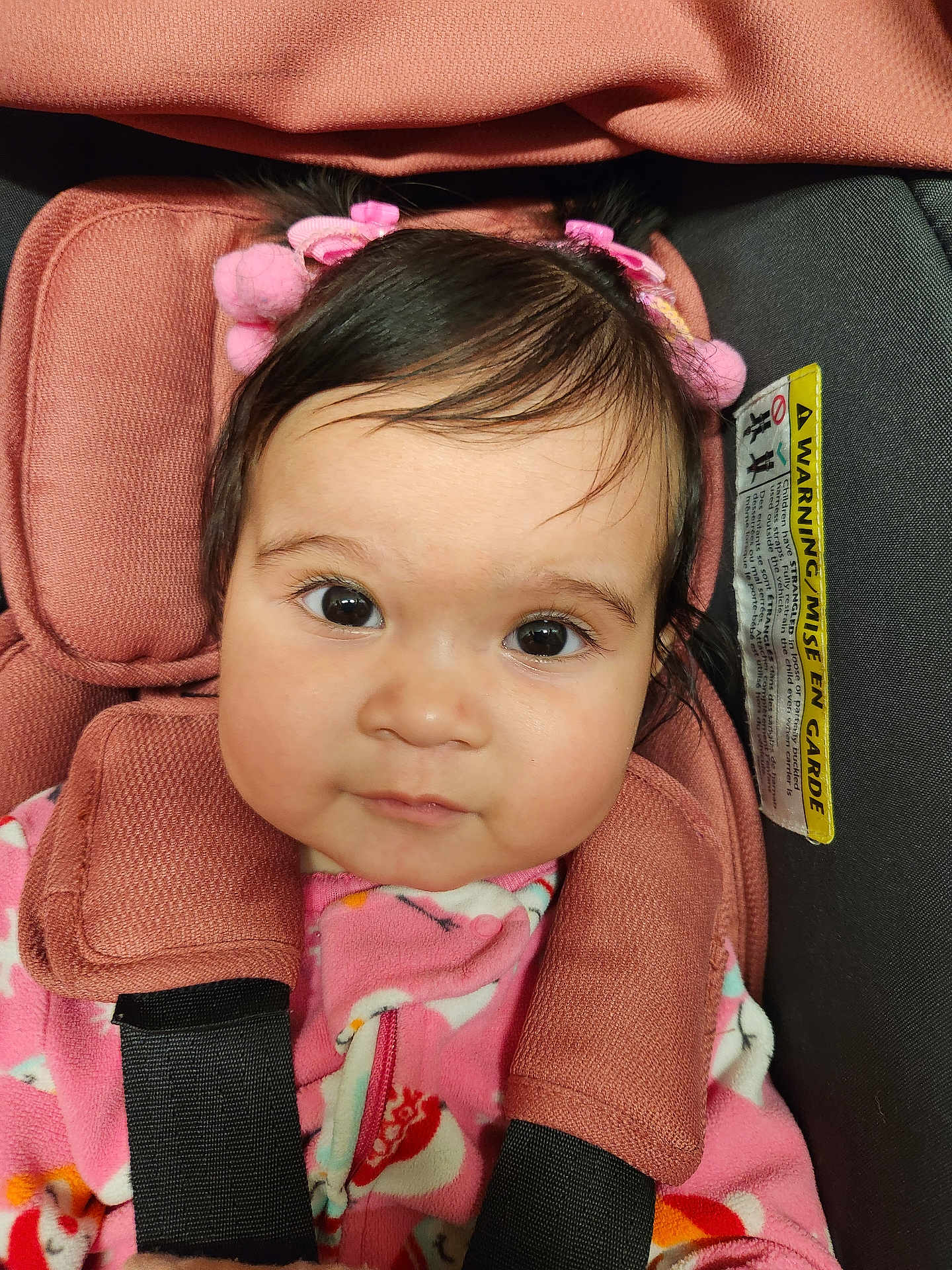 Victoria Evangeline is registered to the contest to win money with this photo: baby, car_seat, child, child_seat, closeup, comfort, cute, expression, eyes, fabric, face, hair_accessories, head, indoors, infant, pink_clothing, portrait, seat, straps, young_child