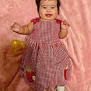 Victoria Evangeline is registered to the contest to win money with this photo: baby, checkered, child, cute, dress, face, happy, indoors, infant, lying_down, pink_blanket, playful, portrait, red_and_white, shoe, smiling, sock, strawberry_patch, toy, yellow_bow