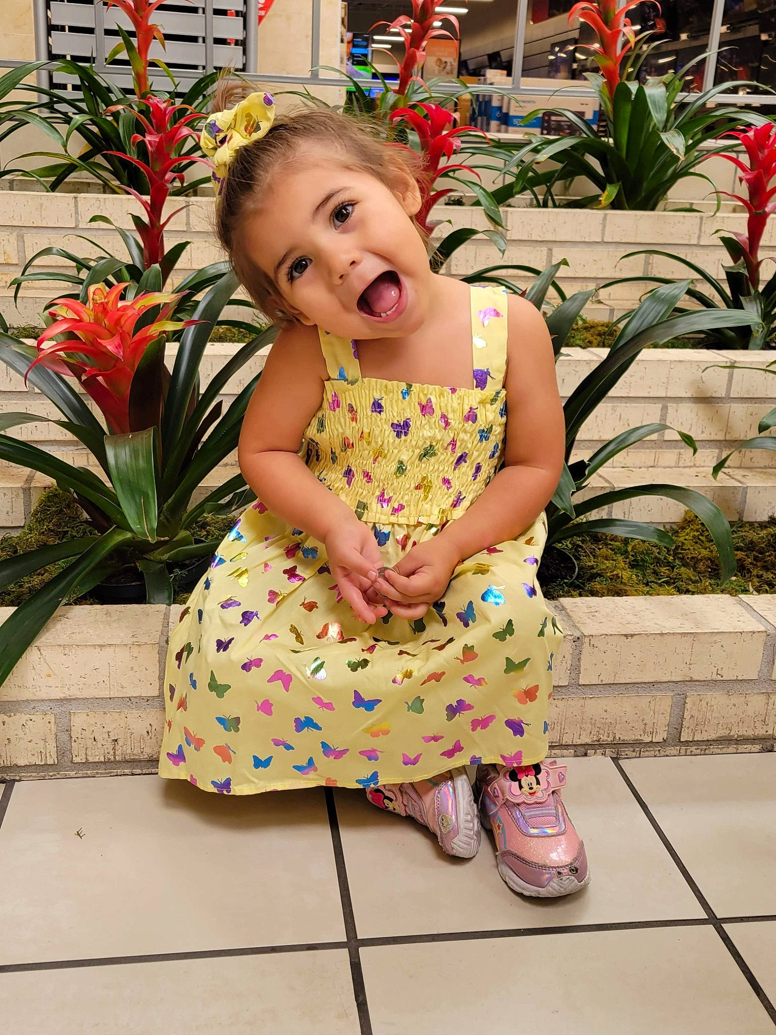 Rosaline is registered to the contest to win money with this photo: baby_toddler_clothing, child, day_dress, dress, flooring, flower, grass, happy, houseplant, human_body, leaf, leisure, pattern, person, pink, plant, sandal, shoe, smile, summer