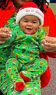 Preston is registered to the contest to win money with this photo: baby, baby_toddler_clothing, child, event, face, finger, fun, grass, green, hand, happy, head, headwear, holiday, leaf, people_in_nature, person, red, skin, sleeve