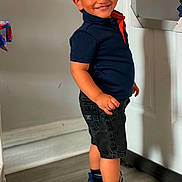 Theo is registered to the contest to win money with this photo: black_shorts, boy, casual_clothing, child, cute, happy, home, indoor, mirror, portrait, posing, red_cap, reflection, shorts, smiling, sneakers, socks, standing, wall_art, wooden_floor