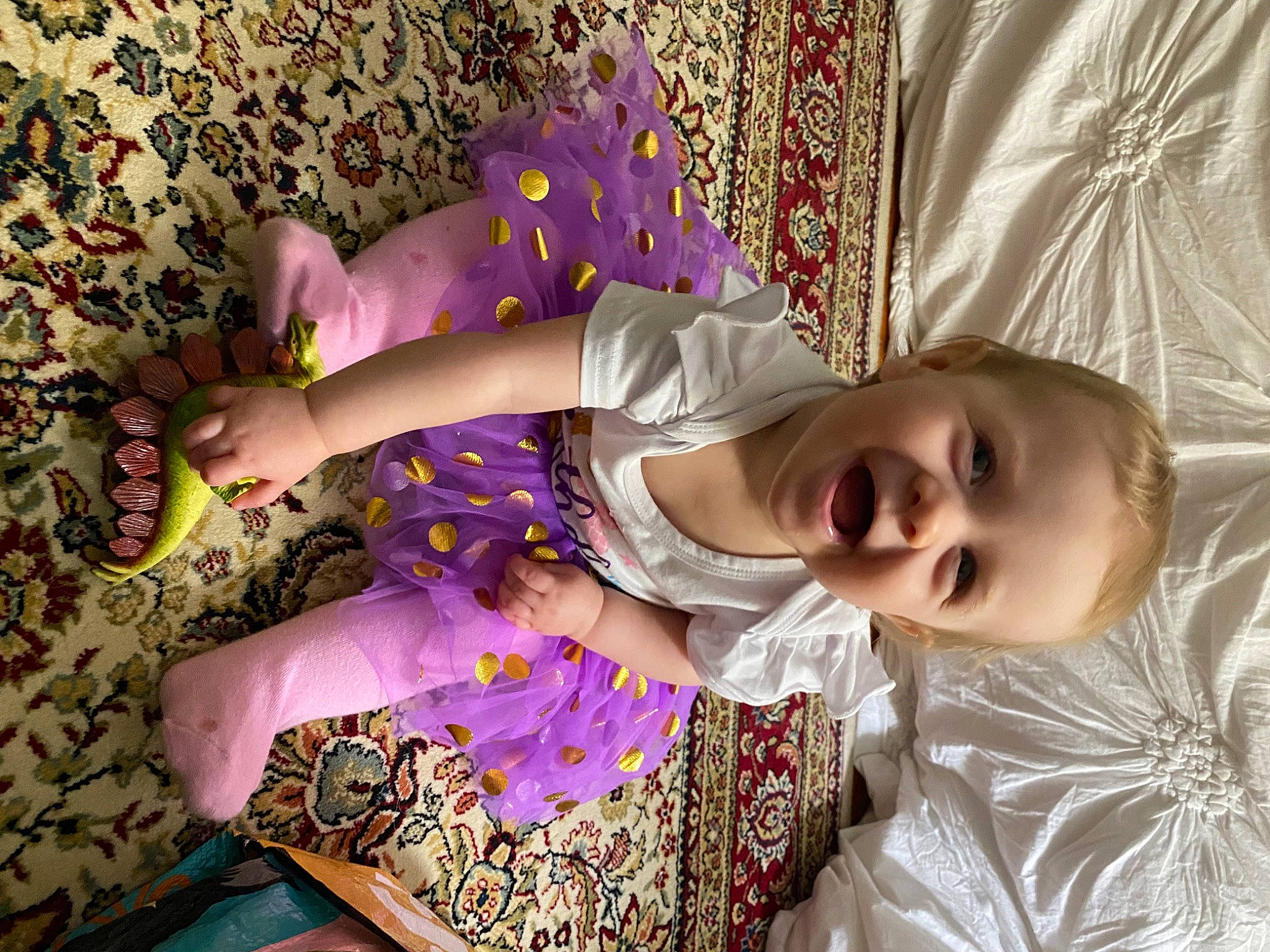 Lily is registered to the contest to win money with this photo: baby, baby_toddler_clothing, child, dress, eye, hand, happy, linens, magenta, pattern, person, pink, plant, purple, skin, sleeve, smile, textile, toddler, tree