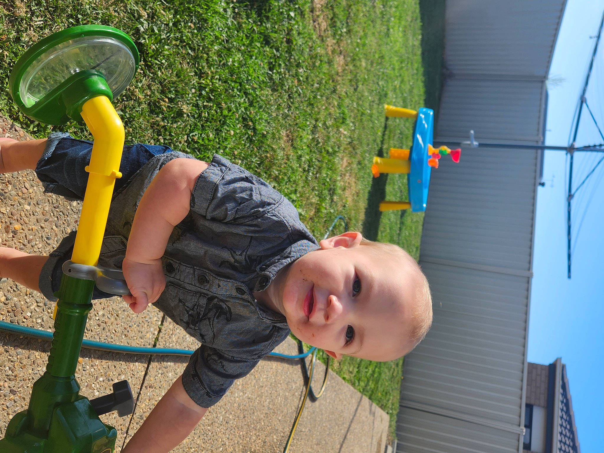 Lincoln is registered to the contest to win money with this photo: baby, child, city, fun, grass, joy, leisure, outdoor_play_equipment, person, plant, play, playground, playground_slide, recreation, shorts, sitting, smile, swing, t_shirt, tire