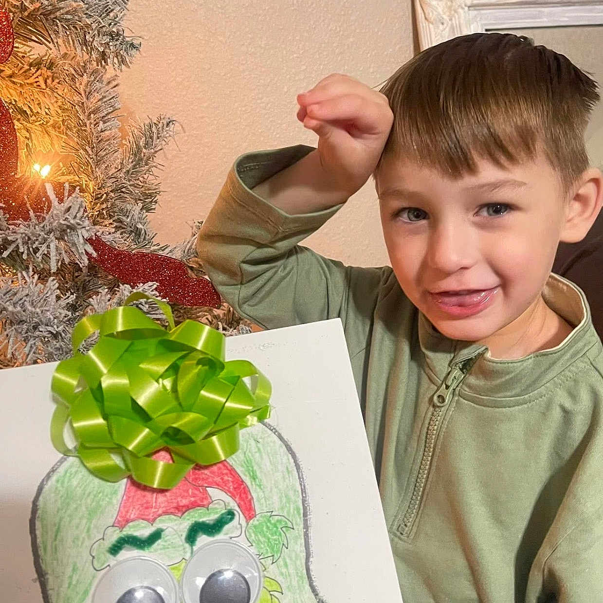 Phoenix is registered to the contest to win money with this photo: boy, child, christmas_tree, craft, decorations, festive, green_bow, grinch, handmade_art, holiday, holiday_cheer, holiday_spirit, indoor, light, playful, portrait, red_decoration, smiling, wall, young_child