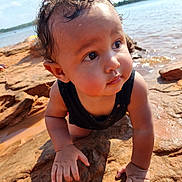 Isa joined the competition — help win amazing prizes! baby, child, curly_hair, wet_hair, rock, water, outdoor, crawling, sunlight, nature, riverbank, face, hands, tank_top, skin, portrait, summer, exploration, expression, closeup