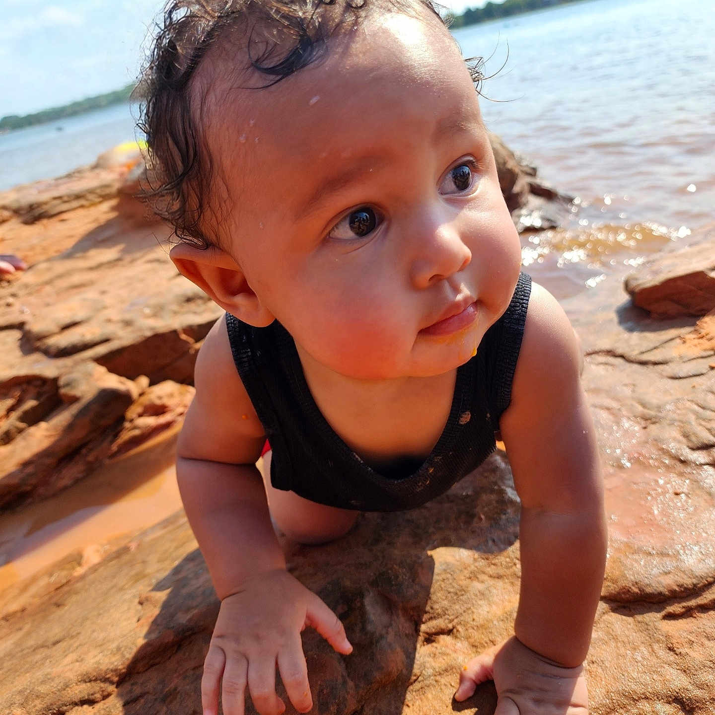 Isa joined the competition — help win amazing prizes! baby, child, closeup, crawling, curly_hair, exploration, expression, face, hands, nature, outdoor, portrait, riverbank, rock, skin, summer, sunlight, tank_top, water, wet_hair
