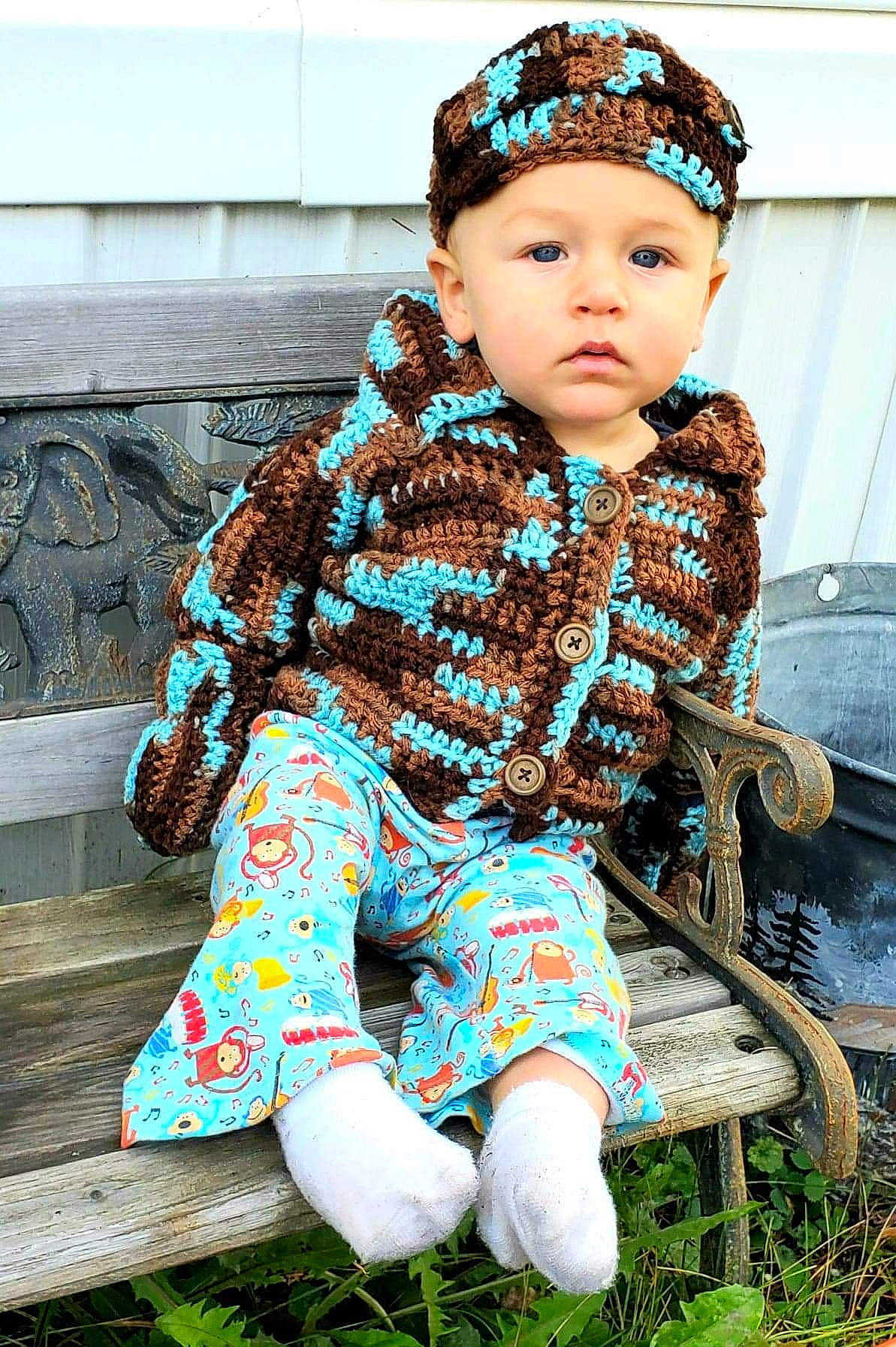 Braxton is registered to the contest to win money with this photo: baby, baby_toddler_clothing, brown, child, child_model, clothing, crochet, design, fashion_accessory, hair_accessory, headgear, headwear, knitting, outerwear, pattern, person, sitting, textile, toddler, wool