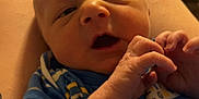 Jamison is registered to the contest to win money with this photo: baby, newborn, infant, blue_blanket, tattoo, hand, arm, close_up, indoor, person, skin, clothing, face, expression, cute, child, sleepy, resting, soft, warm