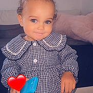 Ava a rejoint le concours — aidez-le/la à gagner de superbes lots ! toddler, child, smiling, curly_hair, indoor, checkered_clothing, blue_toy_phone, cute, portrait, person, furniture, couch, pajamas, hair_buns, earrings, happy, standing, playing, home, cozy