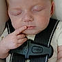 baby, sleeping, car_seat, child, infant, finger, hand, face, closed_eyes, clothing, safety_harness, seatbelt, cute, peaceful, portrait, young_child, resting, indoors, skin, newborn