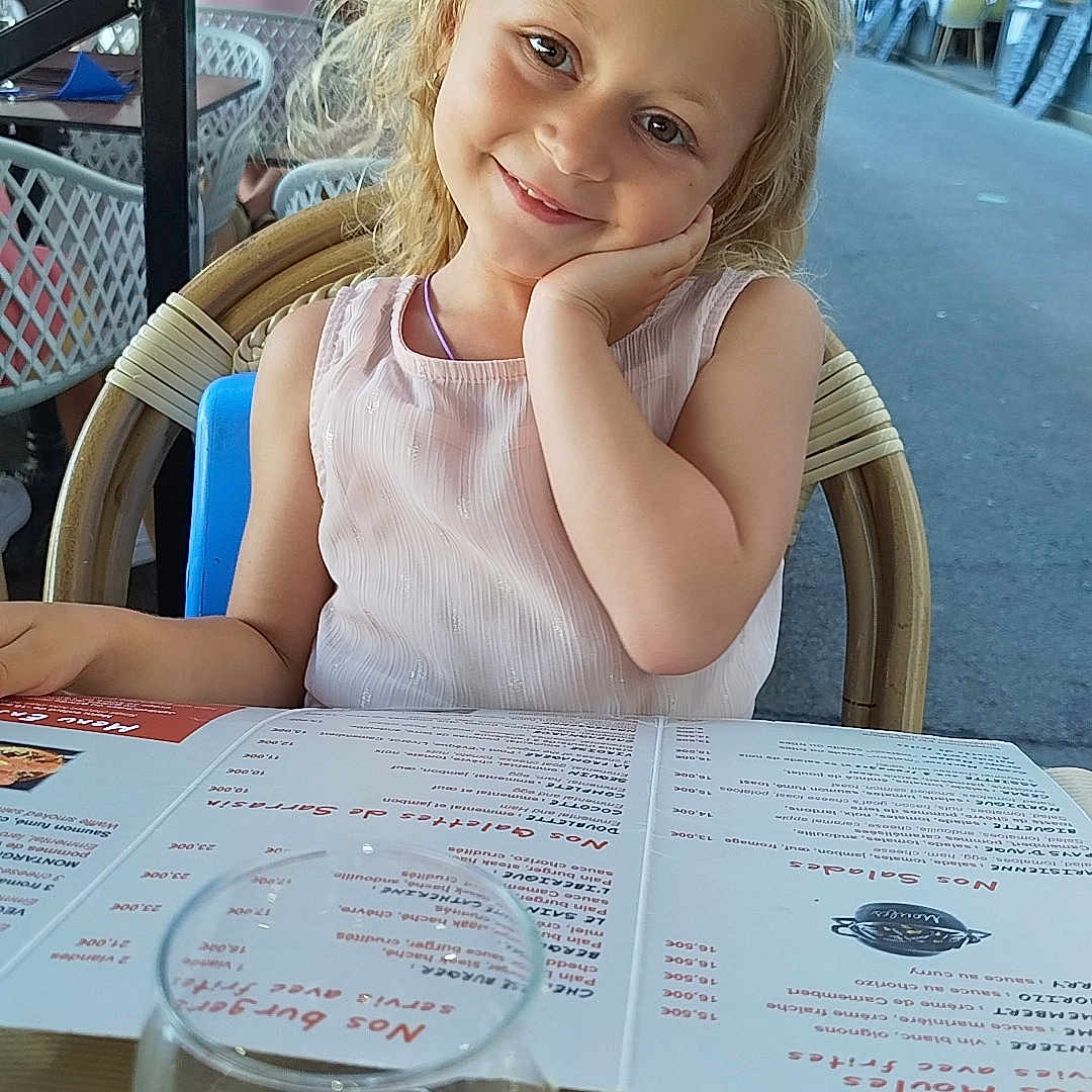 Myla participe au concours pour gagner de l'argent avec cette photo : adult, cafe, cafeteria, child, diningtable, face, female, furniture, girl, glass, head, indoors, menu, person, photography, portrait, restaurant, table, text, woman