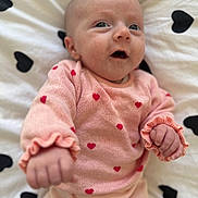 Lyliana a rejoint le concours — aidez-le/la à gagner de superbes lots ! baby, infant, newborn, pink_clothing, heart_pattern, blanket, bedding, portrait, close_up, cute, hands, eyes, mouth_open, knitwear, soft_texture, lying_down, nursery, skin, bedroom, sleepwear