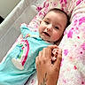 baby, infant, smile, hand, tattoo, blanket, pink, blue_clothing, rainbow, onesie, bed, mesh_side, cute, person, holding_hand, skin, happy, face, lying_down, indoor