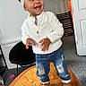 Nevaeh joined the competition — help win amazing prizes! baby, child, toddler, smiling, happy, portrait, indoors, standing, headband, bow, jacket, jeans, boots, wooden_table, chair, door, home, fashion, face, person